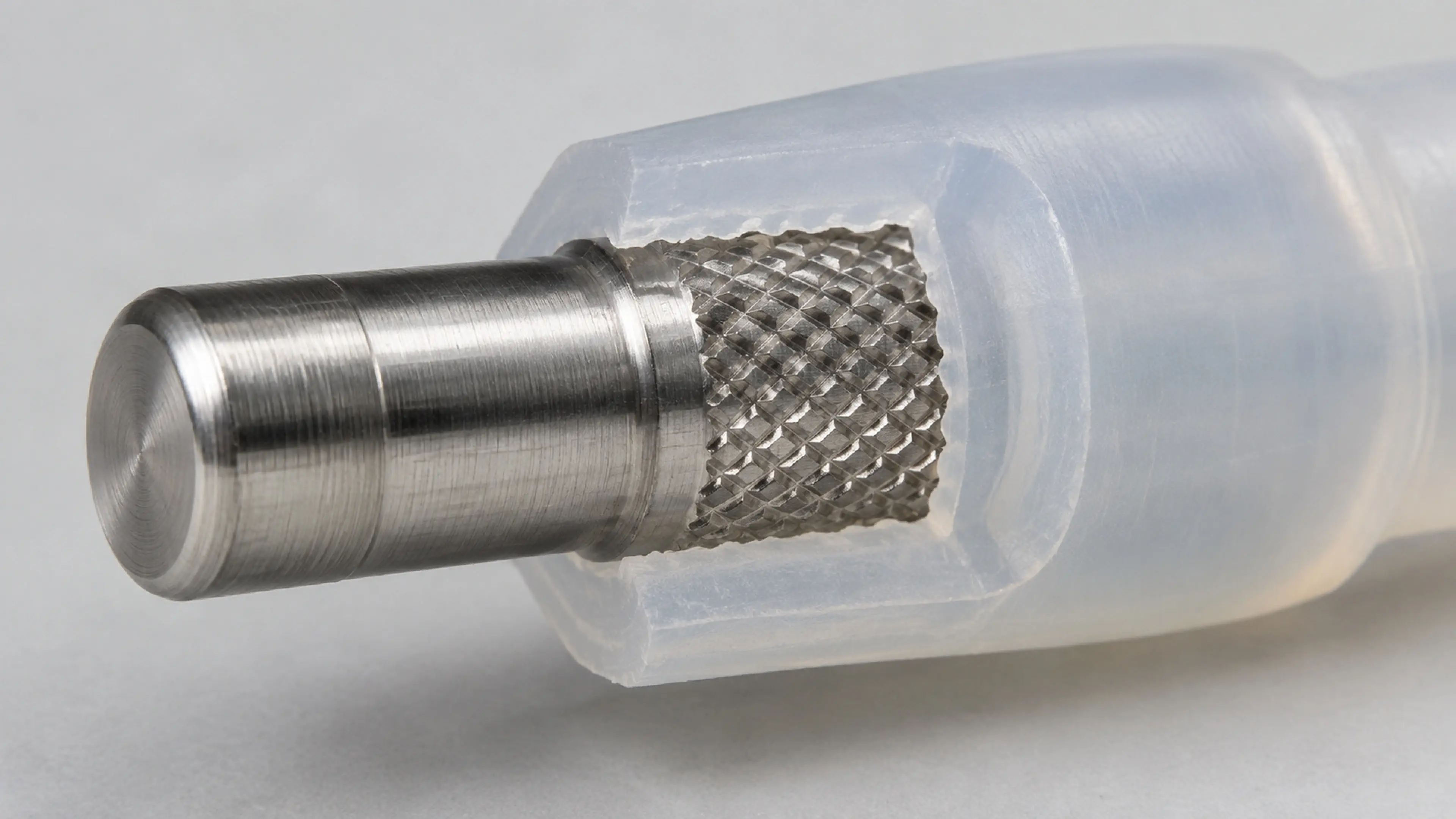 Metal insert with knurled band and barb undercut, partially overmolded with silicone.